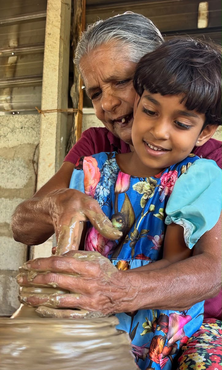 A local potter training a young visitor on the pottery wheel at Hambu Café